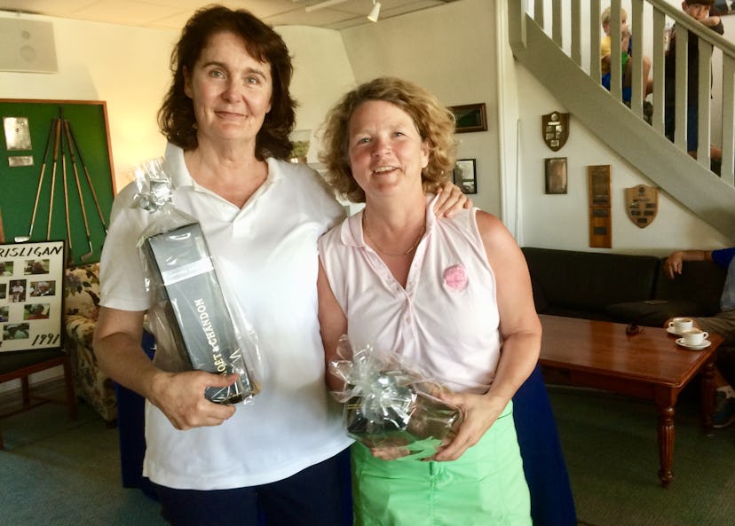 Två vinnare i golftävlingen poserar med sina priser.