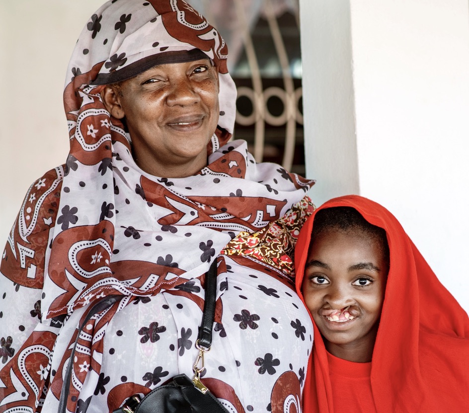 En äldre kvinna och en liten flicka står bredvid varandra, tätt ihop.