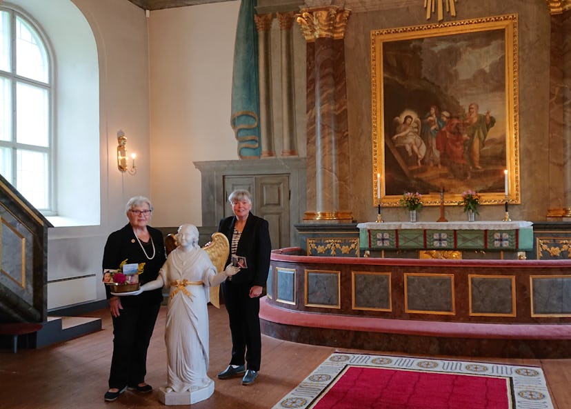 Två kvinnor i en kyrka som står vid altaret