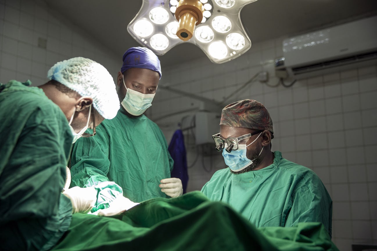 Tre kirurger arbetar med en patient i operationssalen