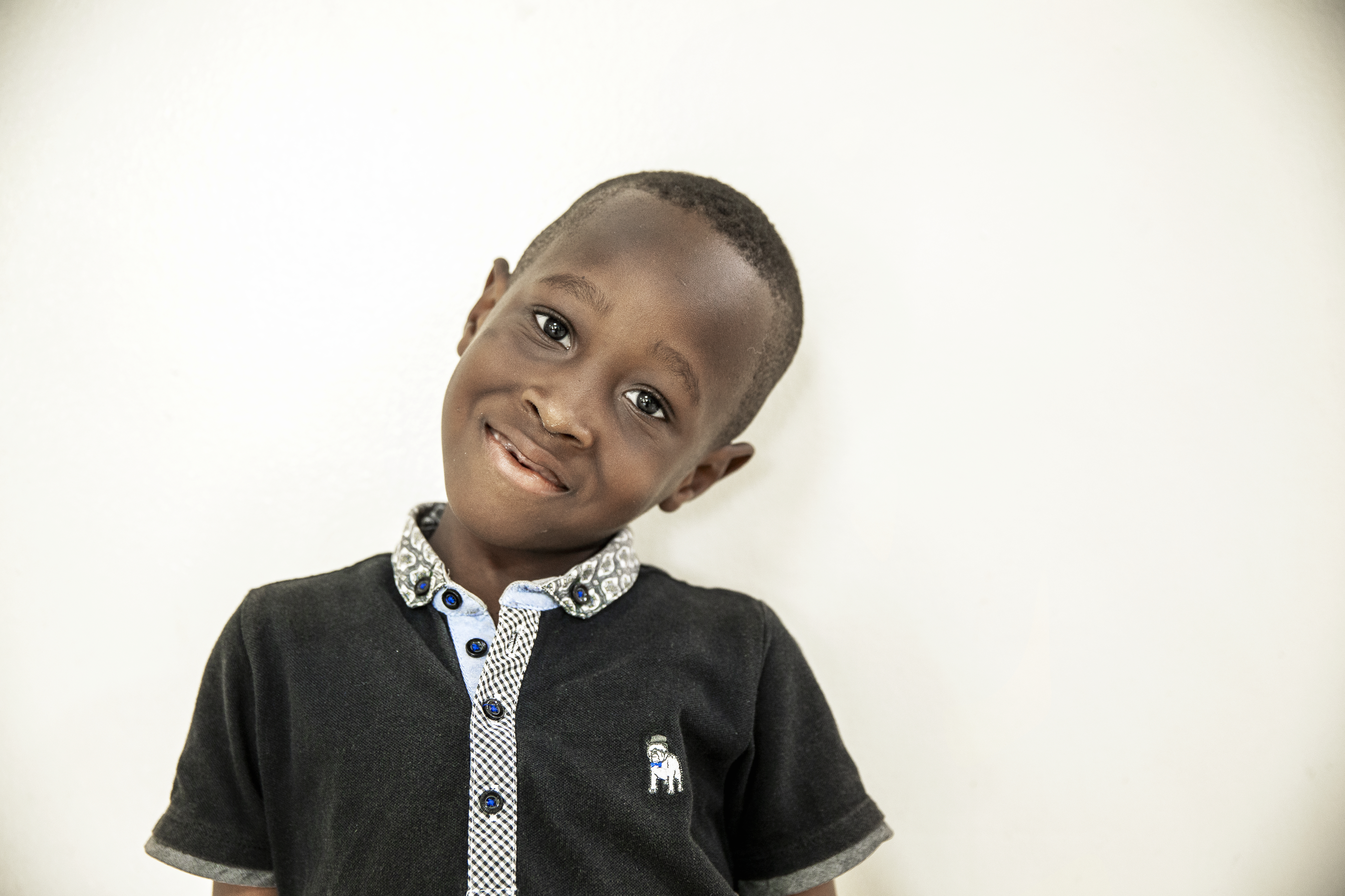 Bryan, med huvudet på sned, ler mot kameran