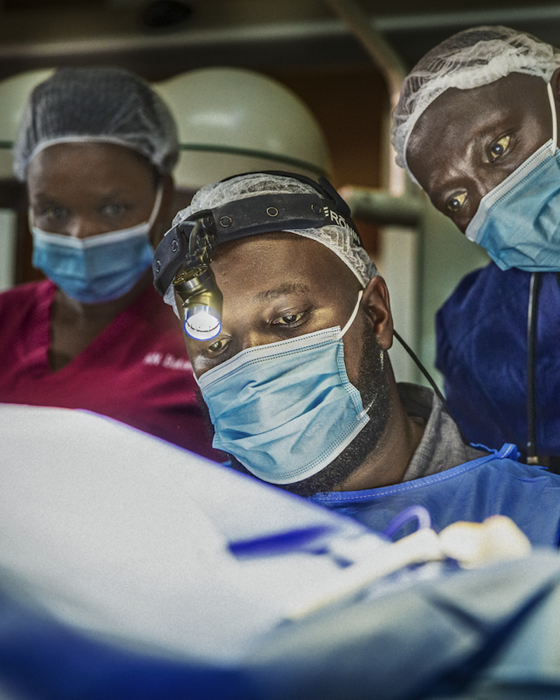 Dr Clovis Baramburiye vid ett operationsbord med medarbetare runt sig.