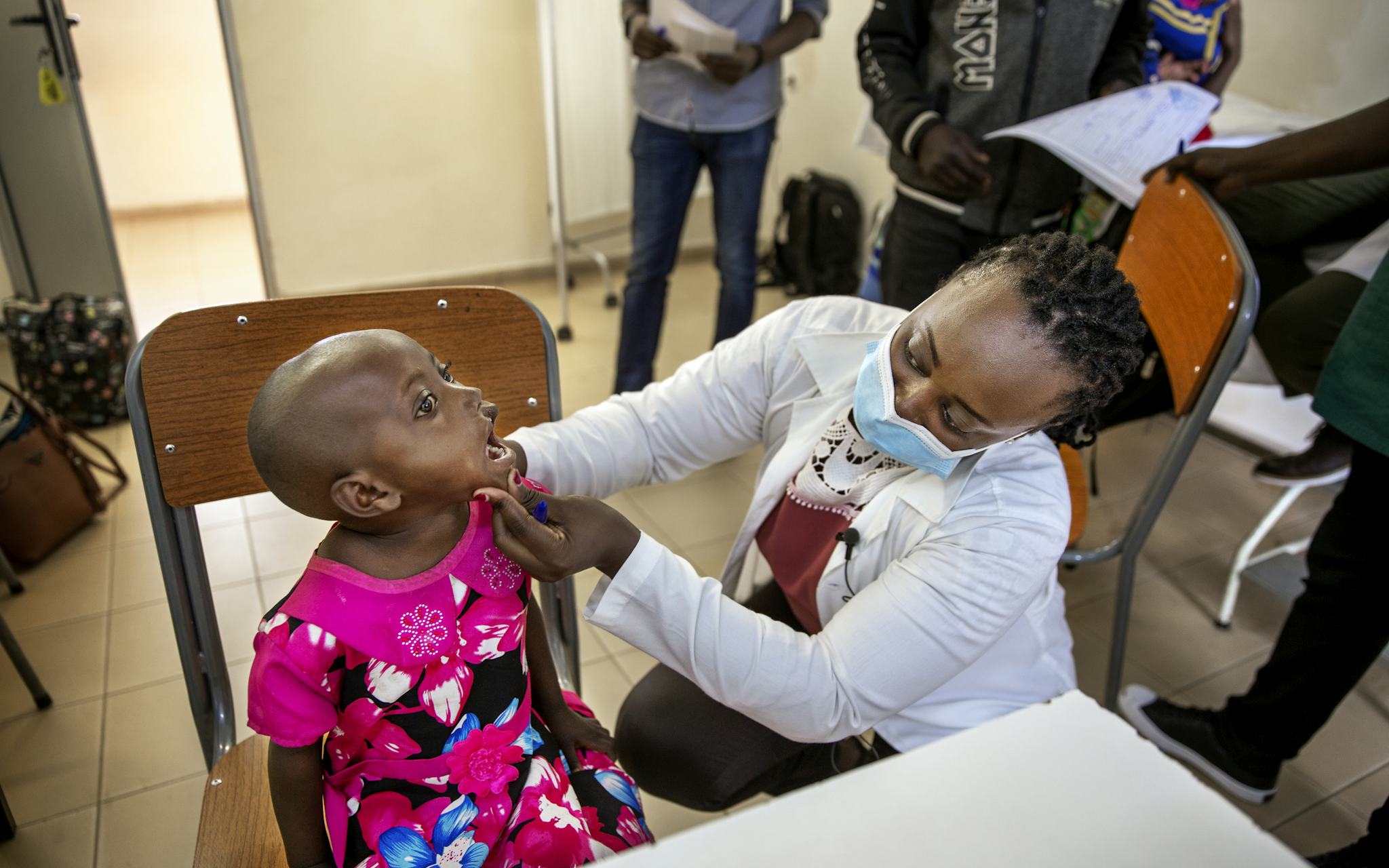 Francoise, plastikkirurg, undersöker Valentine, fem år som gapar stort.