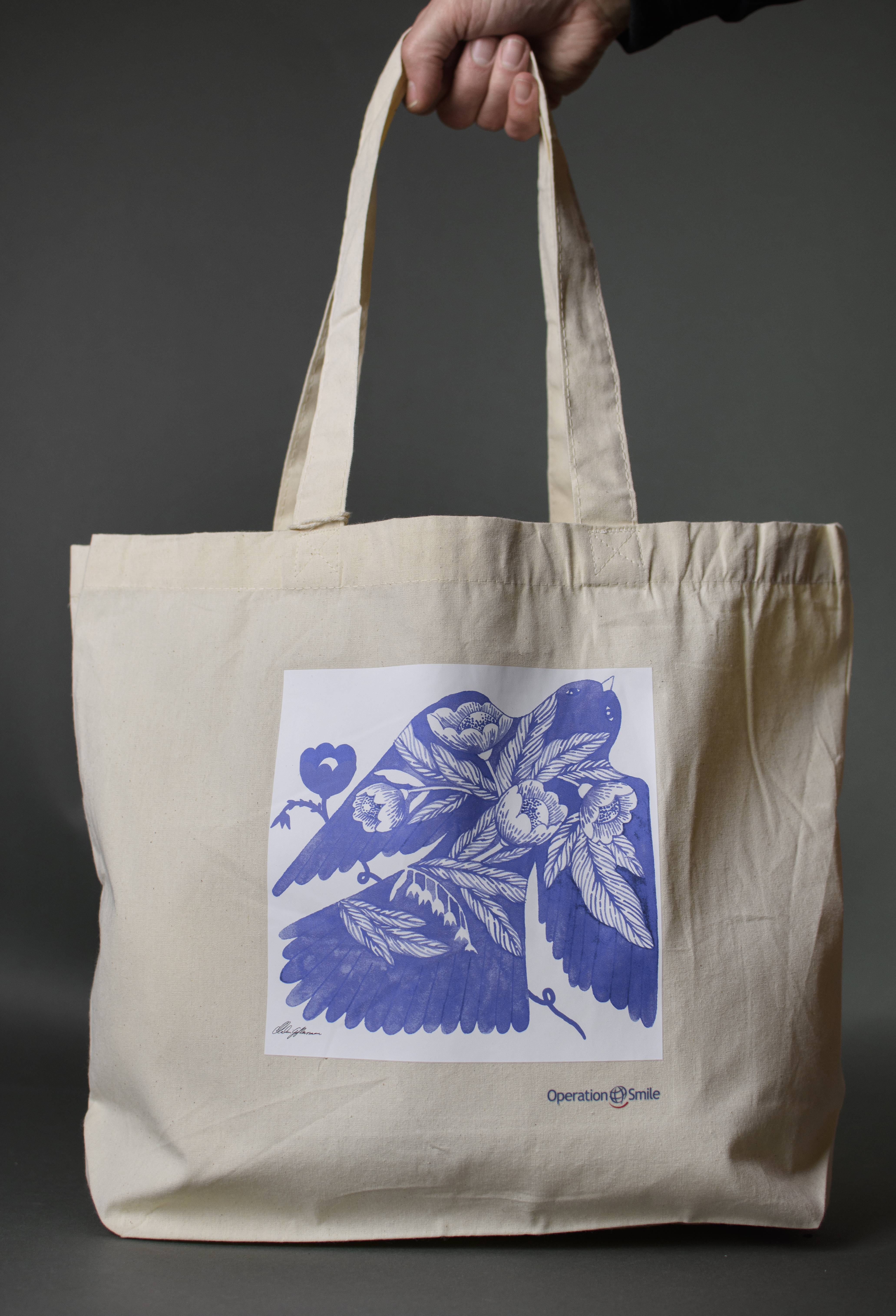 Beige tygkasse med blått mönster.