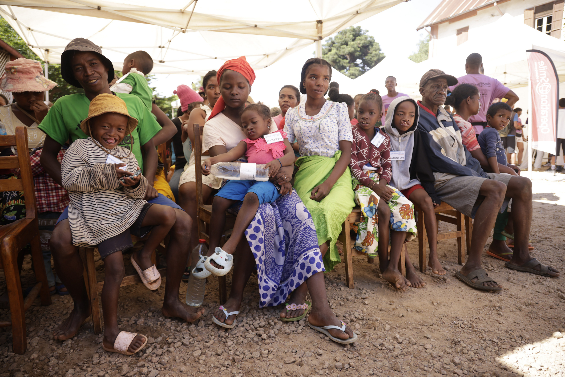 Barn sitter i sina föräldrar knän i väntan på att bli undersökta av läkare.